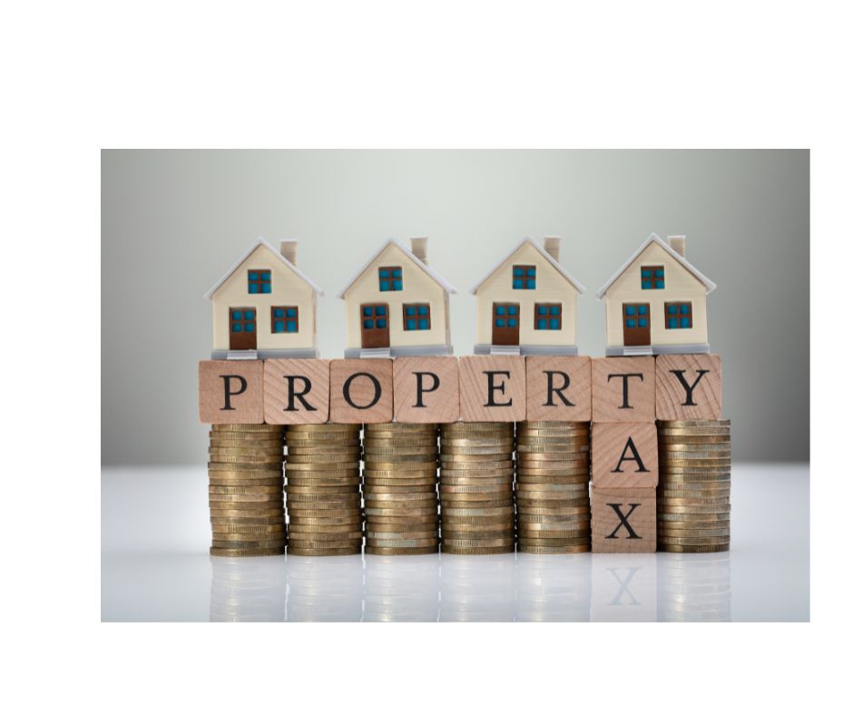 taxes 2 houses on piles of money with the words property taxes