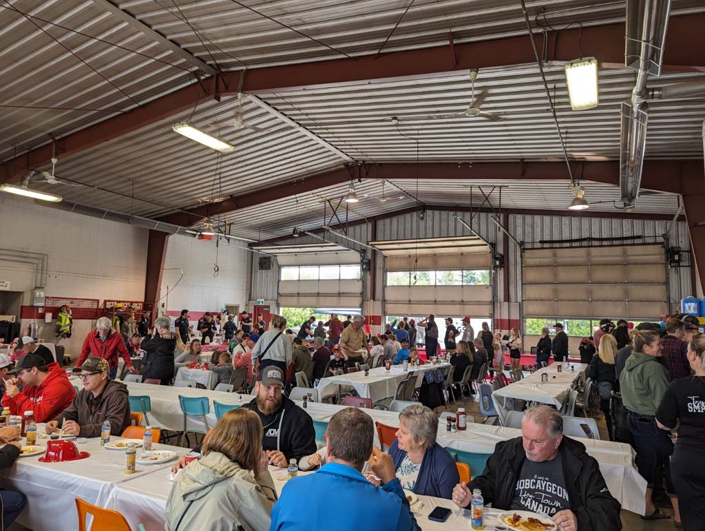 inside firehall showing a room packed with people enjoying breakfast