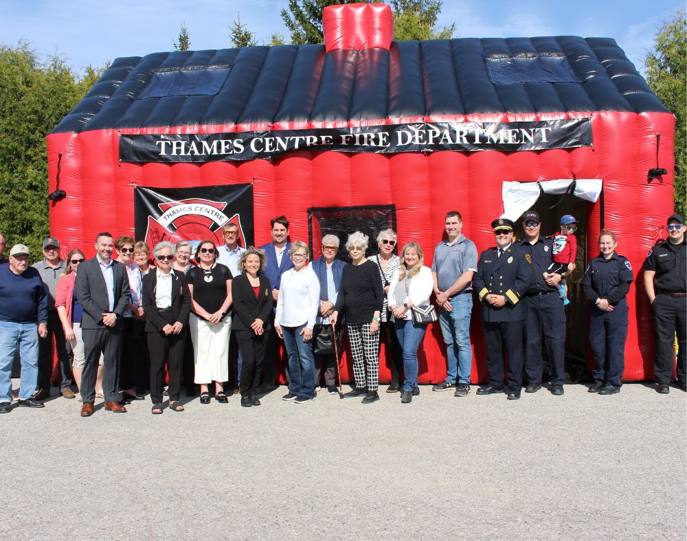 council and staff outside in front of the inflatable house